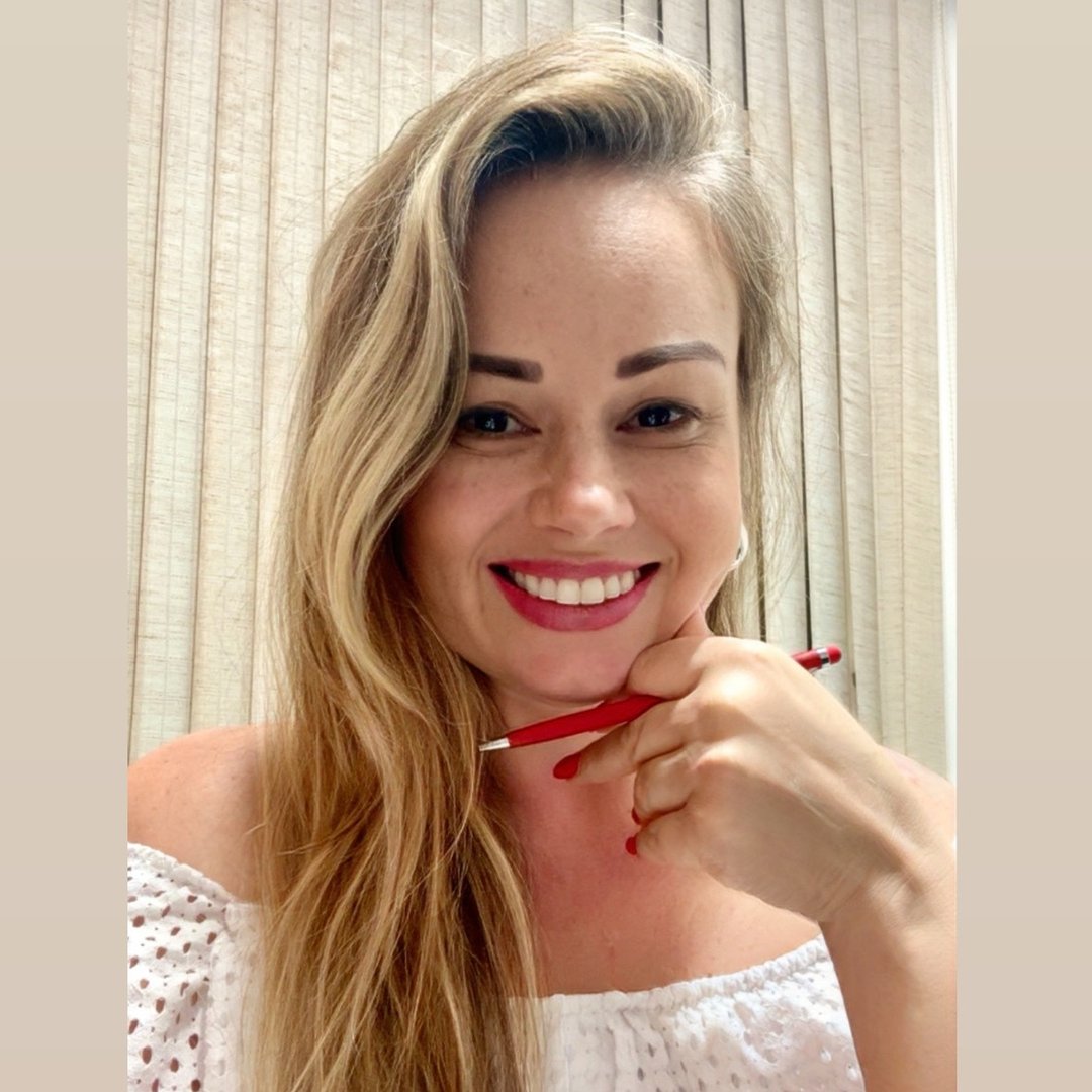 Tatiane Santos sorrindo, com a caneta na mão, pronta para ouvir